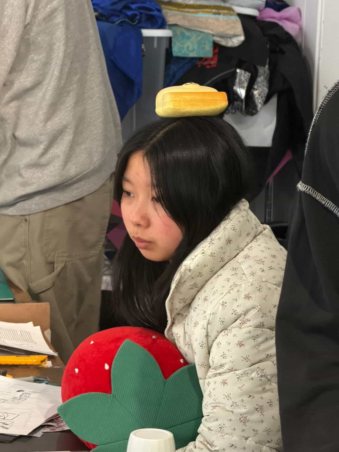 Alice in the design studio with a plush on her head